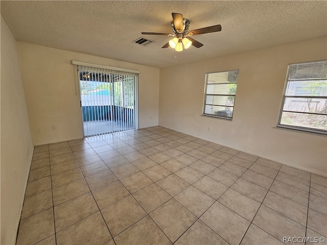 unfurnished room featuring light tile patterned floors, a textured ceiling, and ceiling fan