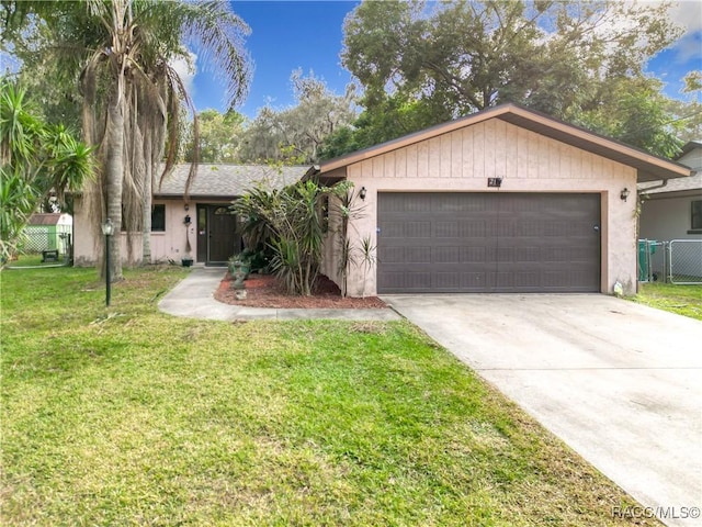 ranch-style home with a garage and a front lawn