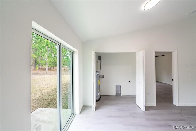 entryway featuring baseboards, light wood-style flooring, water heater, and vaulted ceiling