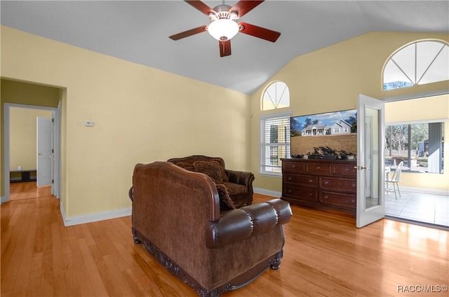 living room featuring ceiling fan, a healthy amount of sunlight, high vaulted ceiling, and light wood-type flooring