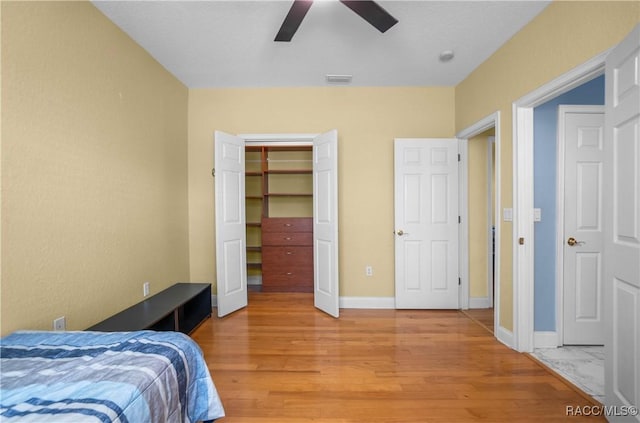 bedroom featuring hardwood / wood-style flooring, ceiling fan, and a closet