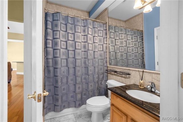 bathroom with tile walls, vanity, toilet, and a shower with shower curtain