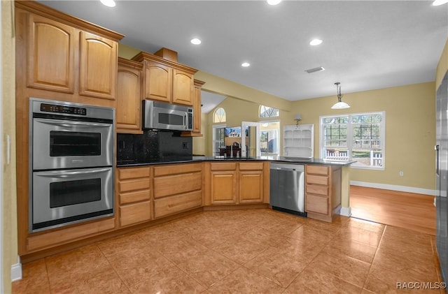 kitchen featuring sink, appliances with stainless steel finishes, backsplash, decorative light fixtures, and kitchen peninsula