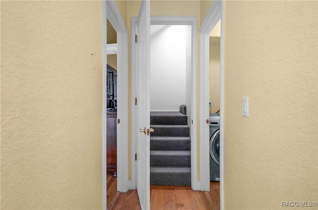 corridor featuring washer / dryer and light hardwood / wood-style floors