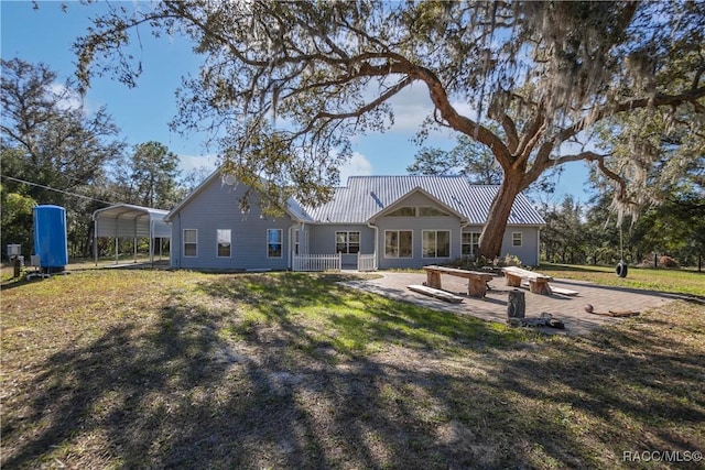 back of property featuring a carport, a yard, and a patio area