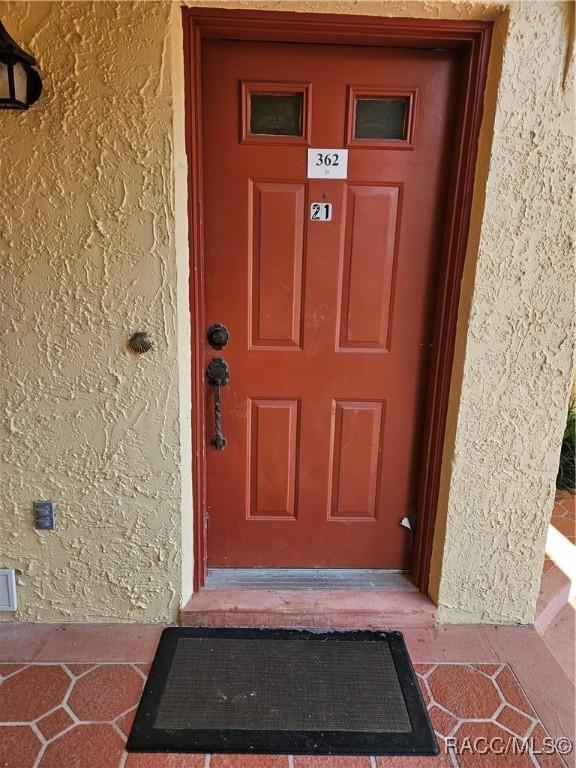 entrance to property featuring stucco siding