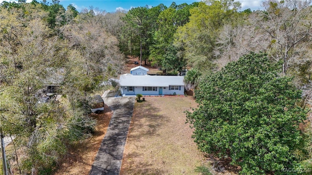 birds eye view of property featuring a view of trees