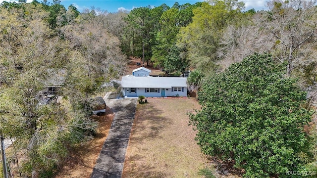 birds eye view of property featuring a view of trees