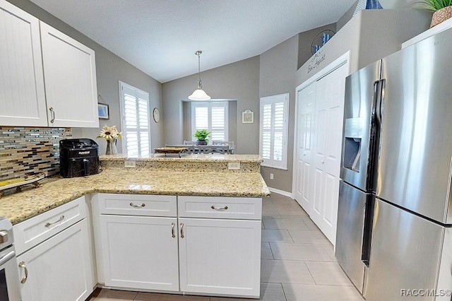 11938 W Blue Bayou Ct Unit 331, Crystal River, FL 34429 - kitchen with tasteful backsplash, stainless steel fridge with ice dispenser, vaulted ceiling, white cabinets, and a peninsula
