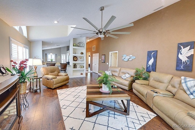 11938 W Blue Bayou Ct Unit 331, Crystal River, FL 34429 - living area with wood finished floors, built in features, vaulted ceiling, visible vents, and a ceiling fan