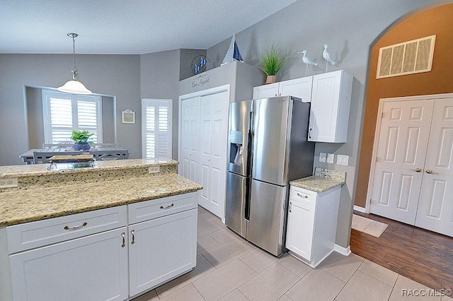11938 W Blue Bayou Ct Unit 331, Crystal River, FL 34429 - kitchen featuring hanging light fixtures, vaulted ceiling, white cabinetry, visible vents, and stainless steel refrigerator with ice dispenser