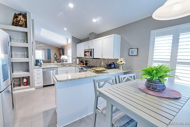 11938 W Blue Bayou Ct Unit 331, Crystal River, FL 34429 - kitchen featuring light stone countertops, a sink, stainless steel appliances, a peninsula, and lofted ceiling