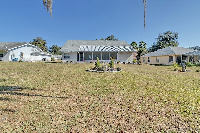 rear view of house featuring a yard