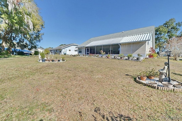 back of property with a lawn and a sunroom