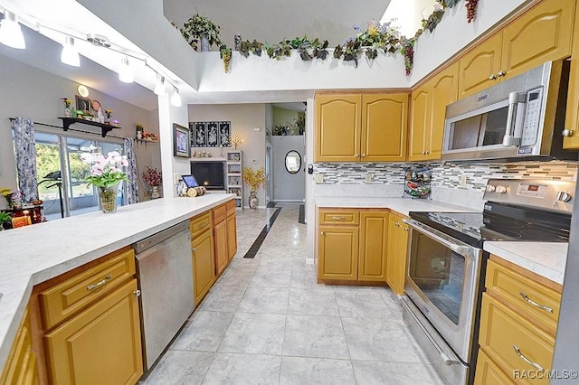 kitchen with decorative backsplash, light tile patterned floors, and appliances with stainless steel finishes