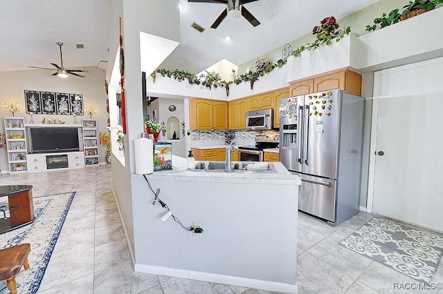 kitchen with appliances with stainless steel finishes, kitchen peninsula, high vaulted ceiling, decorative backsplash, and sink