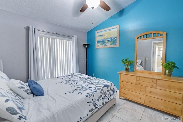 tiled bedroom with a textured ceiling, ceiling fan, and vaulted ceiling