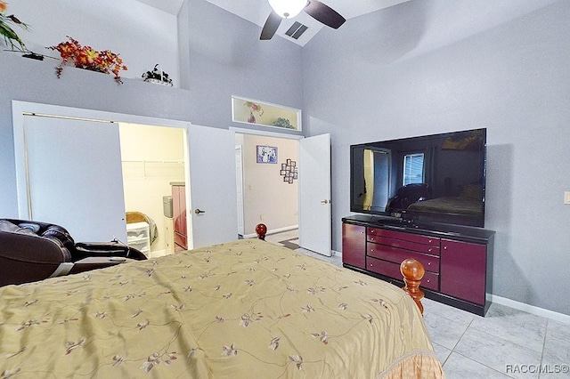 bedroom with a spacious closet, ceiling fan, light tile patterned floors, a closet, and high vaulted ceiling