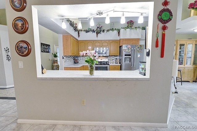 kitchen with stainless steel appliances and decorative backsplash