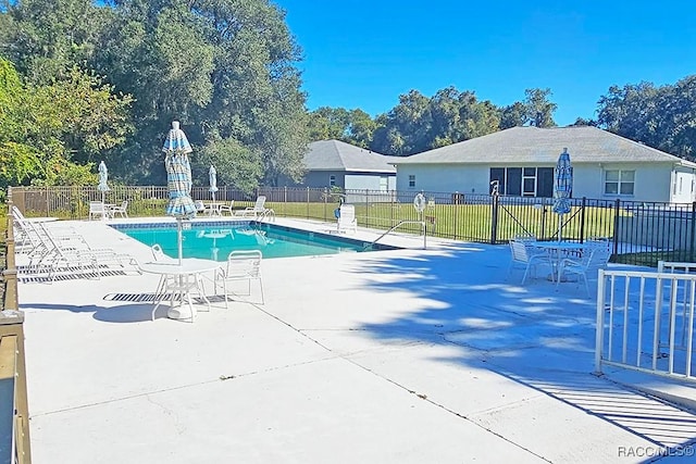 view of pool with a lawn and a patio area