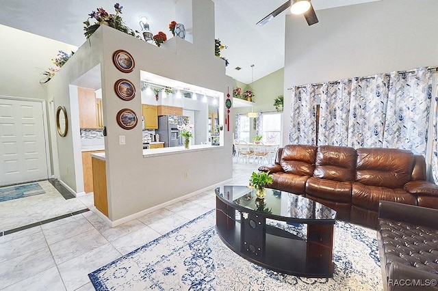 tiled living room with ceiling fan and high vaulted ceiling