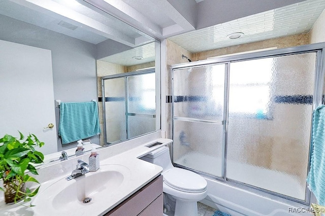 full bathroom with toilet, vanity, and bath / shower combo with glass door