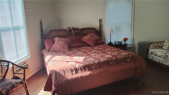 bedroom with hardwood / wood-style floors and radiator heating unit