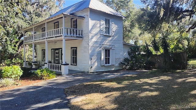 view of side of property with a balcony and a porch