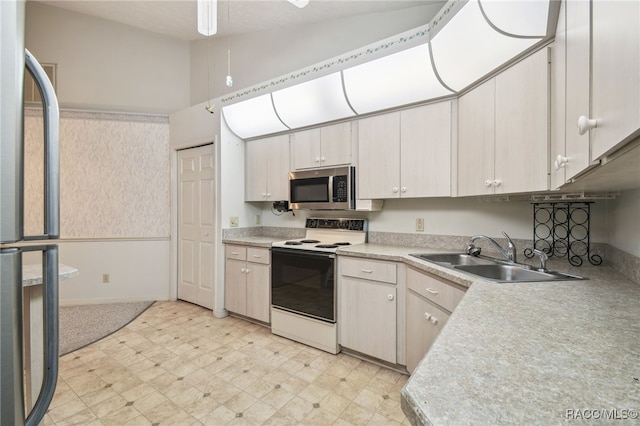 kitchen featuring refrigerator, white range with electric stovetop, and sink