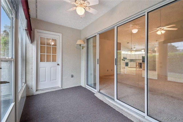 unfurnished sunroom with ceiling fan