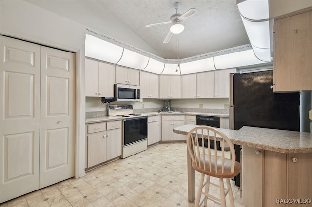 kitchen featuring lofted ceiling, ceiling fan, a textured ceiling, appliances with stainless steel finishes, and kitchen peninsula