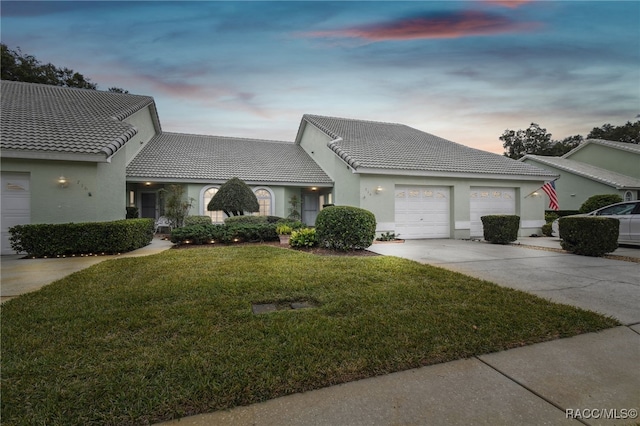 view of front of home with a yard and a garage