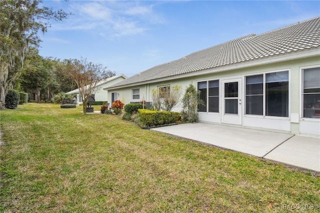 back of property featuring a patio area and a yard