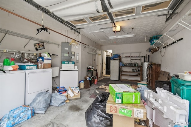 garage featuring washer and clothes dryer, electric panel, and a garage door opener