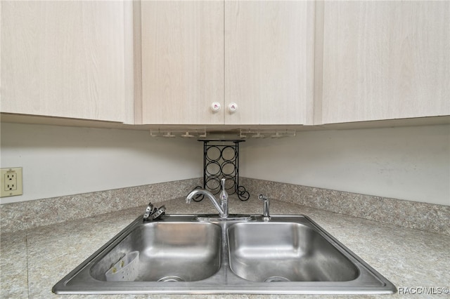 interior details featuring light brown cabinetry and sink