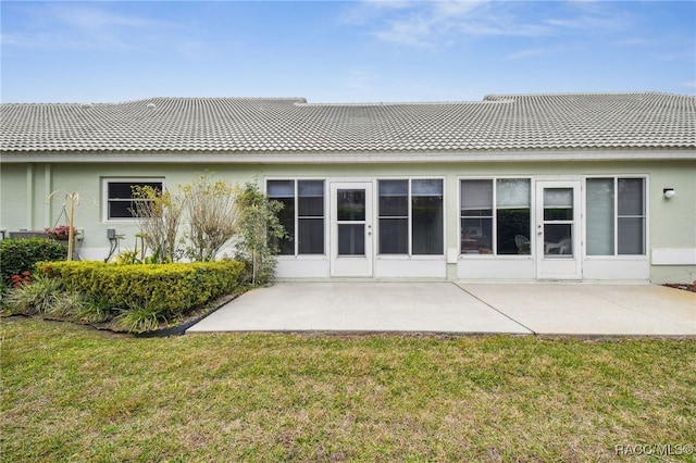 rear view of house featuring a lawn and a patio area