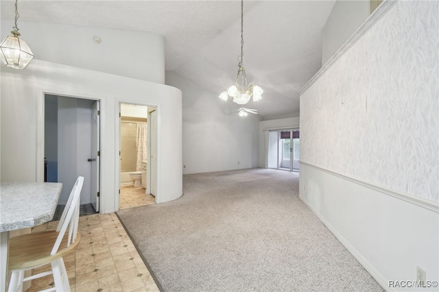 unfurnished dining area with light colored carpet, a chandelier, and lofted ceiling