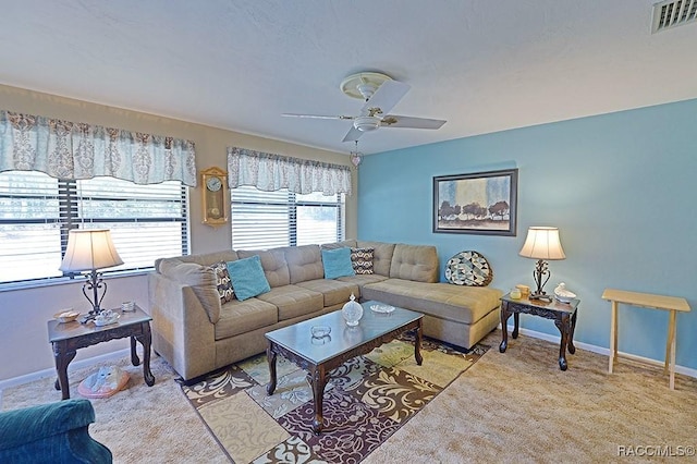 living room with baseboards, visible vents, ceiling fan, and light colored carpet