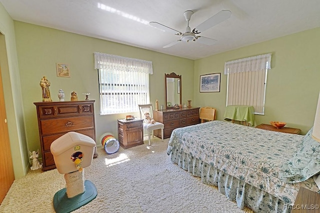 bedroom with light carpet and a ceiling fan