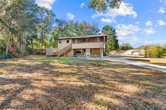 rear view of property with a storage shed and a lawn