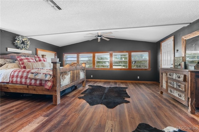 bedroom with lofted ceiling, ceiling fan, dark hardwood / wood-style floors, and a textured ceiling