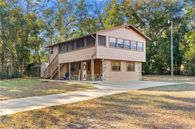 view of front of home featuring a sunroom and a front yard