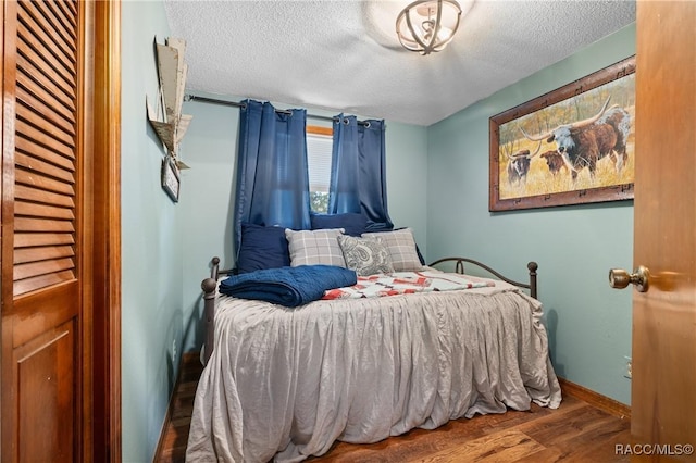 bedroom with wood-type flooring and a textured ceiling