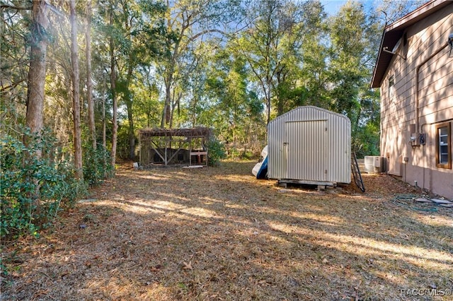 view of yard with a storage shed and central air condition unit