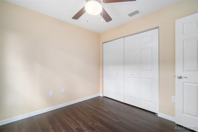 unfurnished bedroom with a closet, dark hardwood / wood-style floors, and ceiling fan