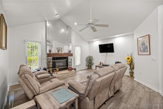 9530 SW 189th Ct, Dunnellon, FL 34432 - living area with ceiling fan, light wood-style flooring, a glass covered fireplace, baseboards, and high vaulted ceiling