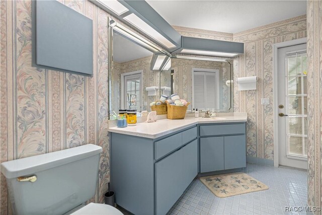 9530 SW 189th Ct, Dunnellon, FL 34432 - bathroom with wallpapered walls, tile patterned floors, toilet, healthy amount of natural light, and vanity