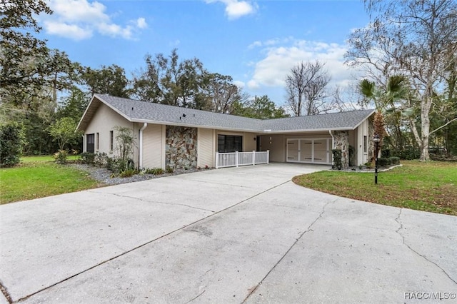 single story home with concrete driveway, stone siding, a front lawn, and a garage