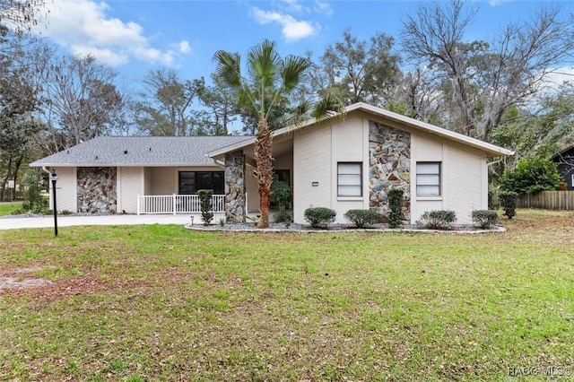 mid century modern with a front lawn, covered porch, and stone siding