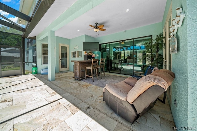 view of patio with ceiling fan and a bar